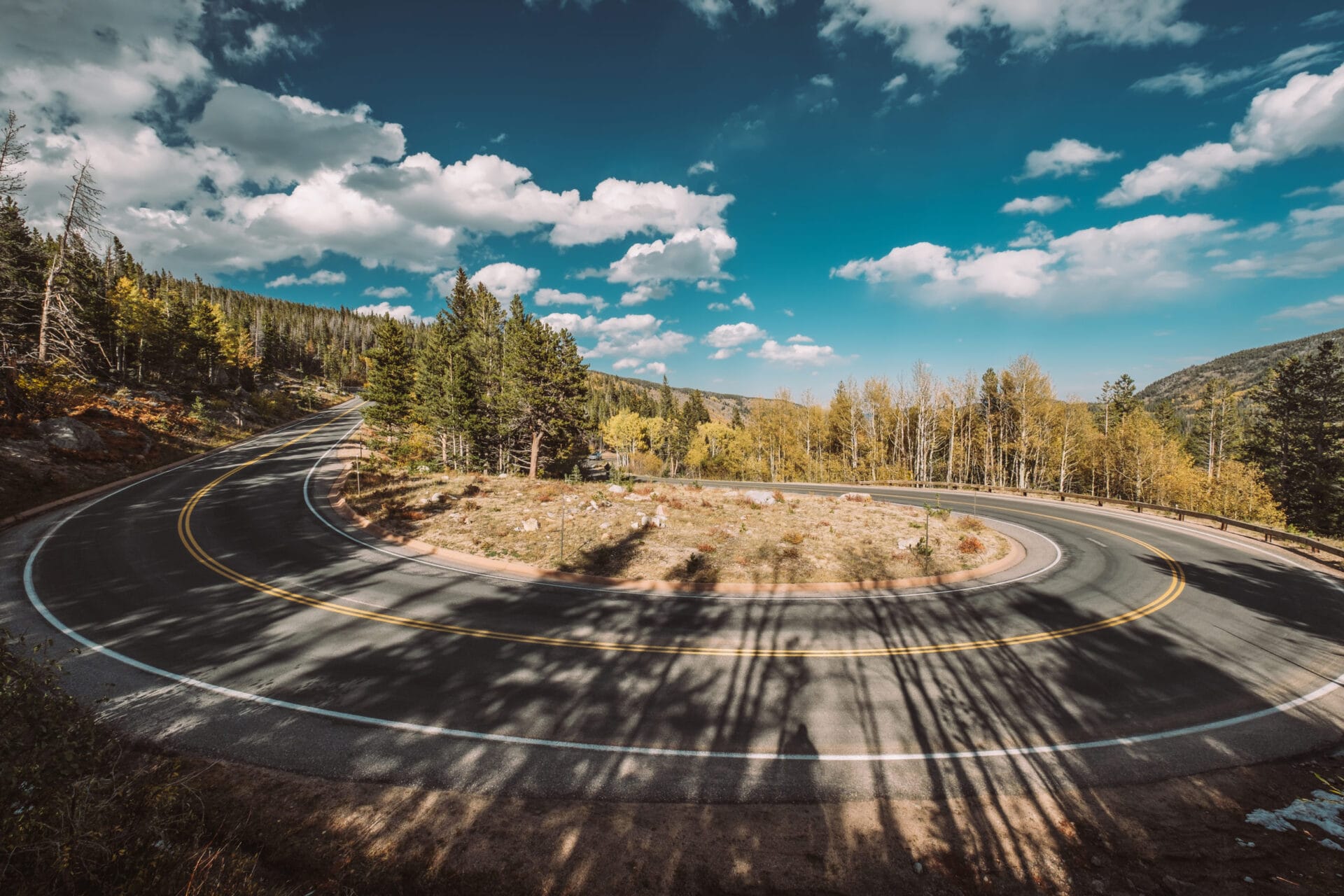 Highway with hairpin turn (switchback) at autumn sunny day in Rocky Mountain National Park. Colorado, USA.