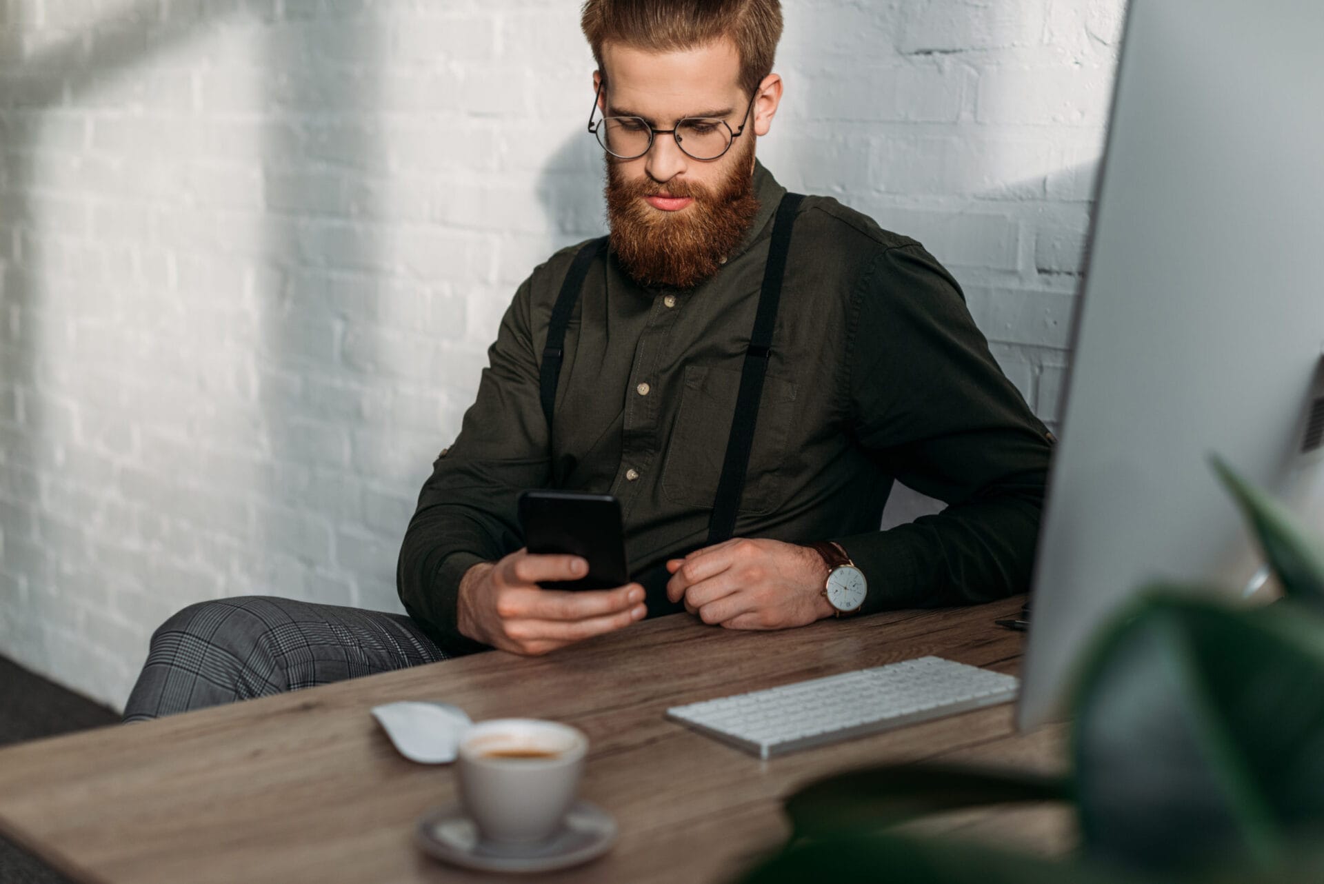 handsome businessman sitting and using smartphone in office