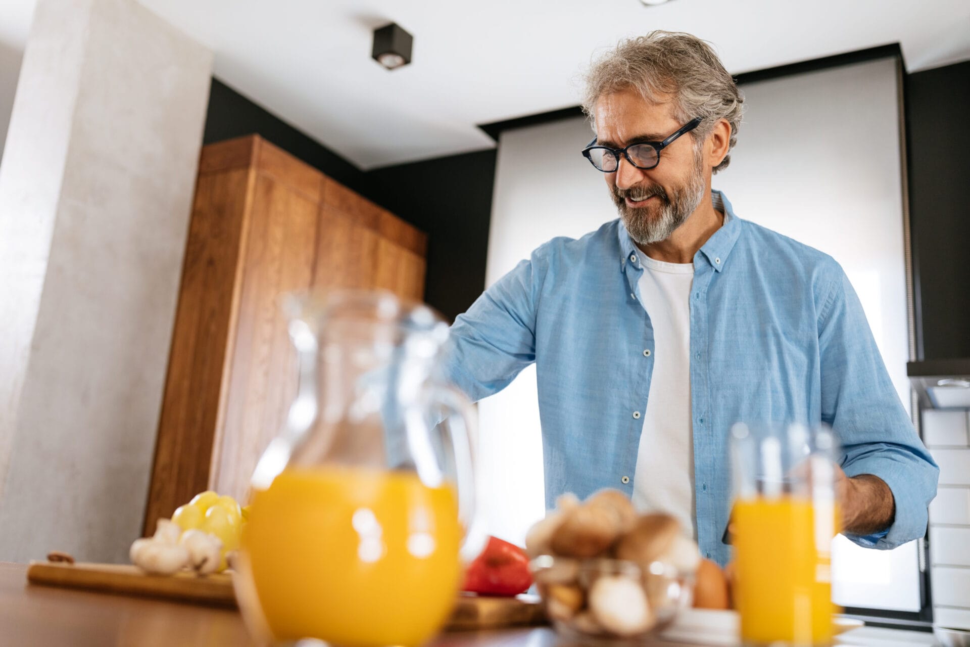 Elderly man is preparing some healthy food in his kitchen