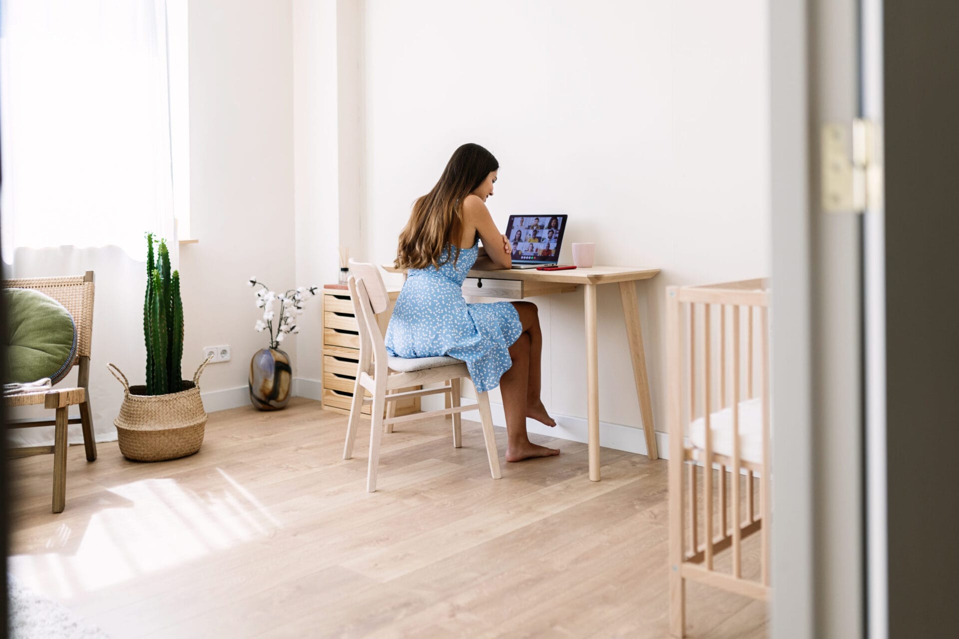 Young mother working from home having a video call with colleagues in the bedroom