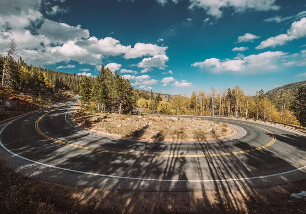 Highway with hairpin turn (switchback) at autumn sunny day in Rocky Mountain National Park. Colorado, USA.