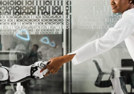 panoramic shot of african american businesswoman shaking hands with robot in office