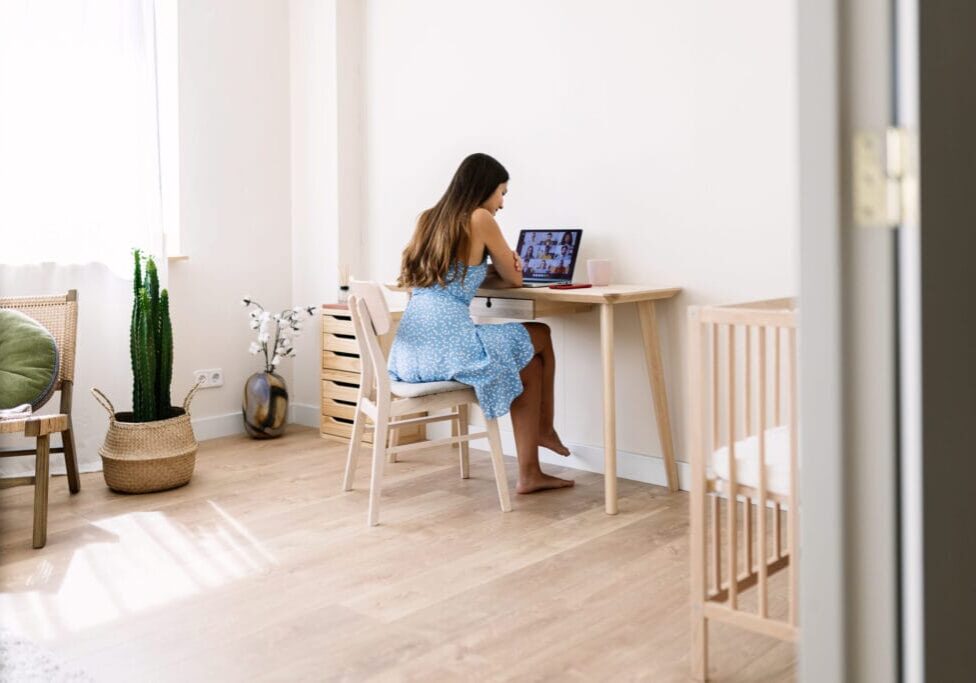 Young mother working from home having a video call with colleagues in the bedroom